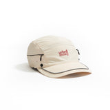 Front view of cream nylon sun cap with rust-red embroidered logo, zip pocket, and snap button. Urban Monkey®