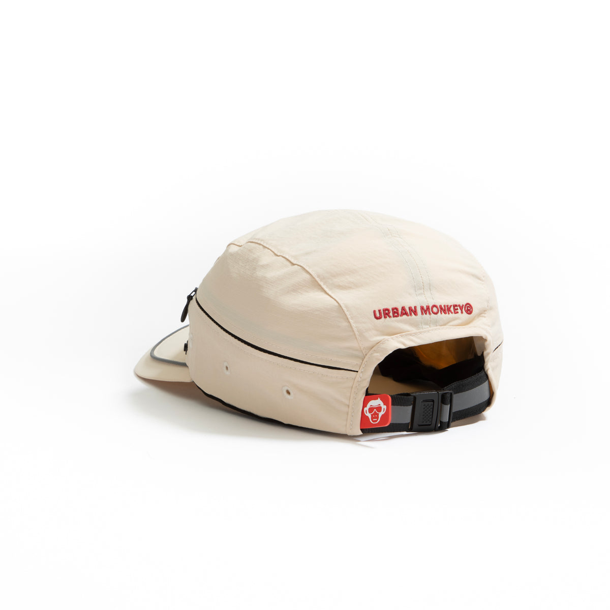 Back view of cream nylon sun cap with rust-red embroidered logo, zip pocket, and adjustable strap. Urban Monkey®