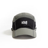 Front view of olive-grey and black color-block nylon cap with white stacked logo and pine tree icon. Urban Monkey®