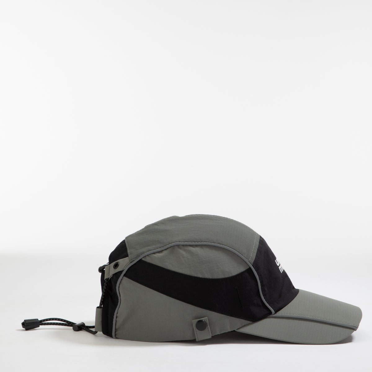 Side view of olive-grey and black color-block nylon cap with white stacked logo and metal side clip. Urban Monkey®