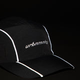 Front view of black ripstop nylon cap with grey piping, sunglasses eyelet white embroidered logo Urban Monkey®